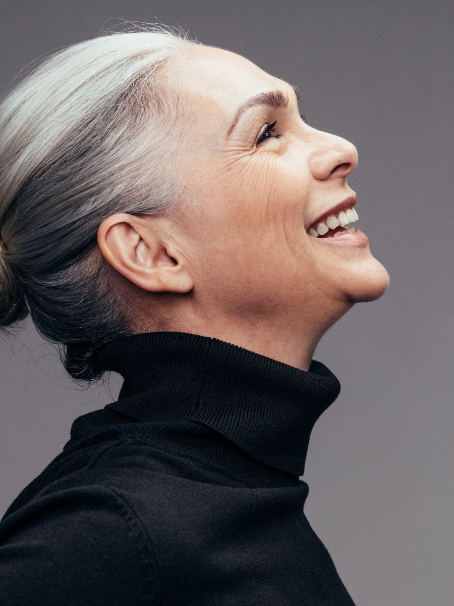 mature woman with her hair pulled back in a bun wearing a black turtle neck